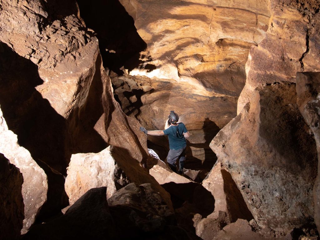 Person hiking down rocks within the caverns