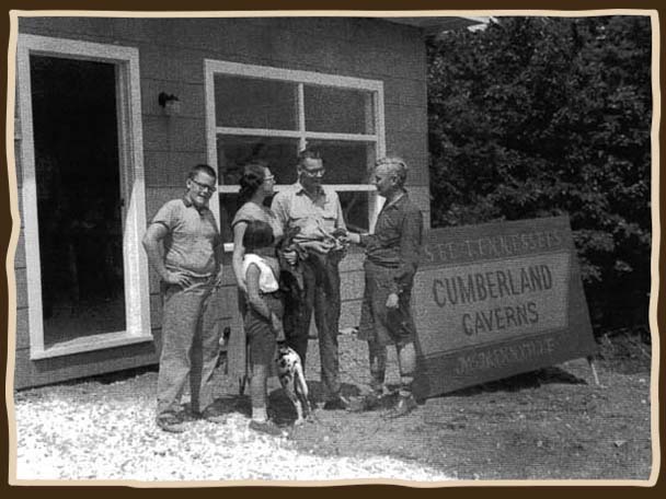 Black and white photo of 5 people and a dog standing in front of the old Cumberland Caverns sign