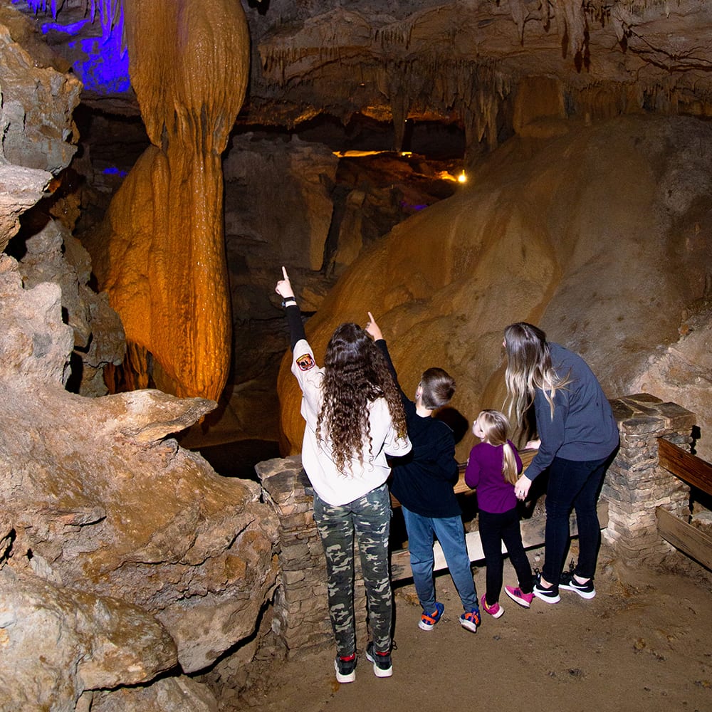 Kids Pointing at Stalactite in Cave