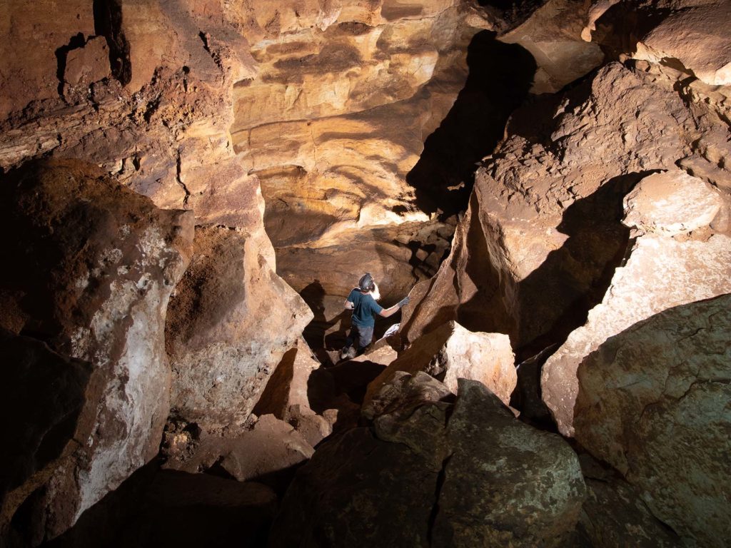 Person hiking down rocks within the caverns