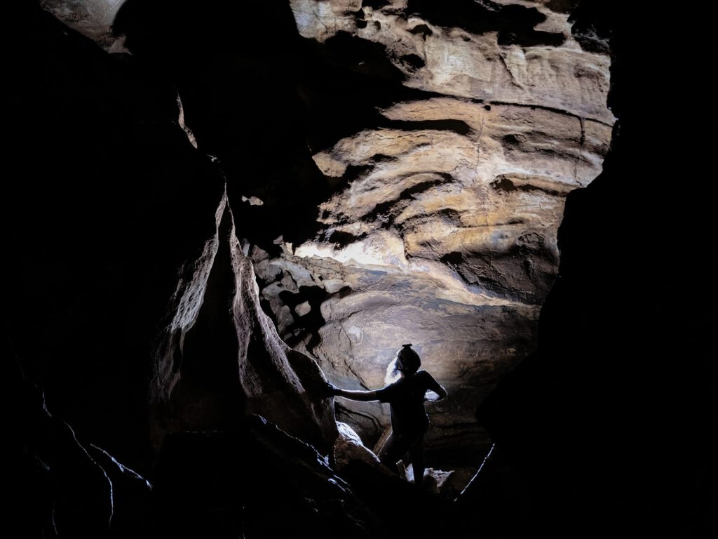 Person looking up at a rock formation in the caverns